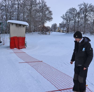 David installe les filets pour matérialiser sa gare. Cela permet de protéger les skieurs qui vont prendre la remontée mécanique de ceux qui descendent.